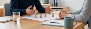 Realistische Arbeitsszene zum Thema «Das Kritikgespräch: Struktur, Prinzipien und häufige Fehler»: 1. Sachlich, 2. Konkret, 3. Dialog, 4. Vereinbarung.